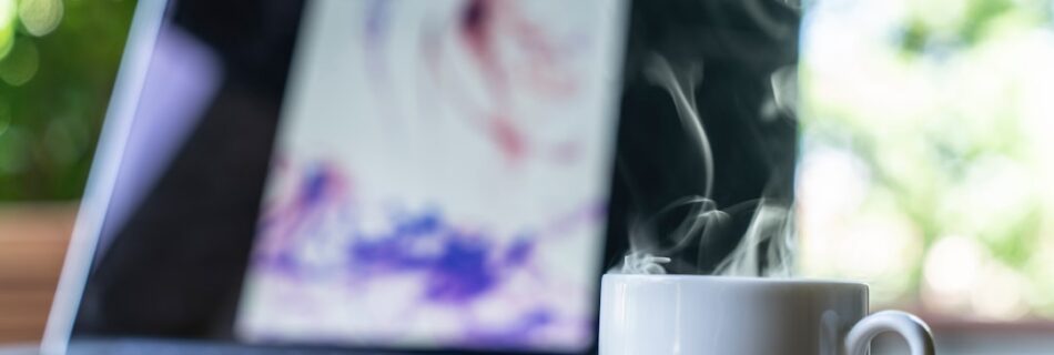 shallow focus photography of white ceramic mug near laptop